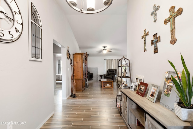 corridor with a notable chandelier, lofted ceiling, and dark wood-type flooring