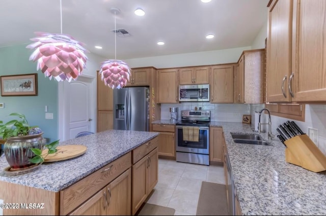 kitchen featuring appliances with stainless steel finishes, light tile flooring, light stone counters, backsplash, and sink