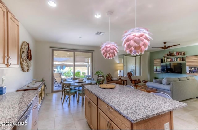 kitchen featuring pendant lighting, a center island, light stone counters, ceiling fan, and light tile floors