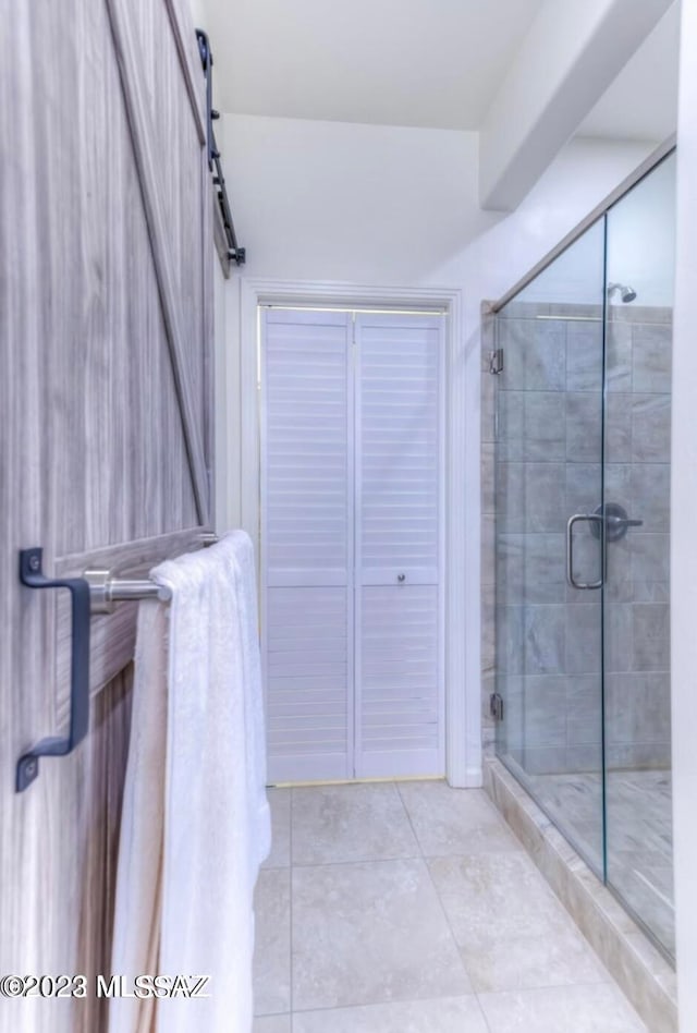 bathroom with an enclosed shower and tile floors