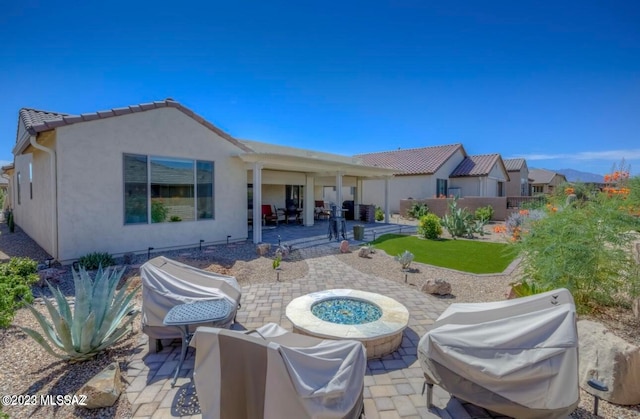 back of property featuring a fire pit and a patio