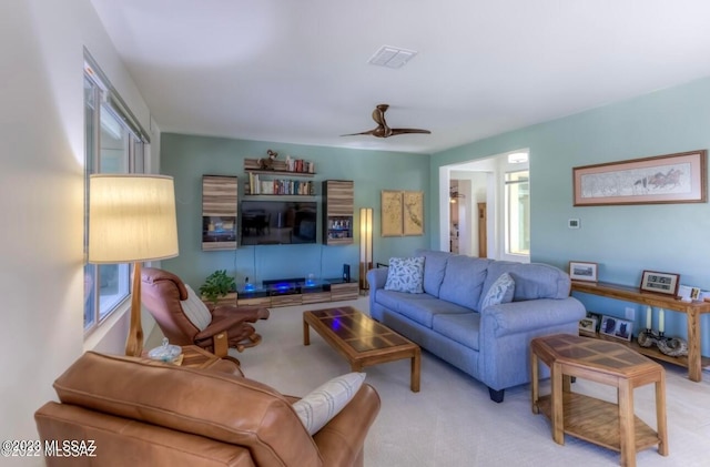 living room with ceiling fan, a wealth of natural light, and light colored carpet