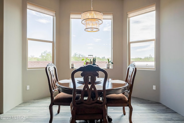 dining space with a notable chandelier and light hardwood / wood-style flooring