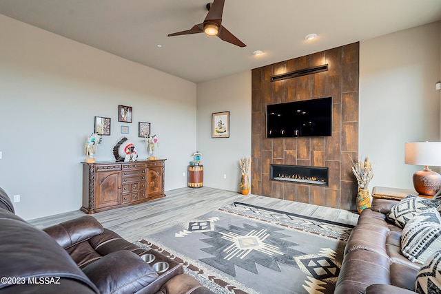 living room featuring a fireplace, light hardwood / wood-style flooring, and ceiling fan