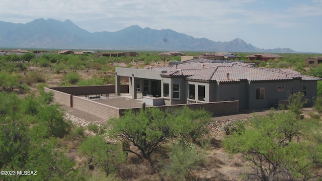 rear view of property featuring a patio area and a mountain view