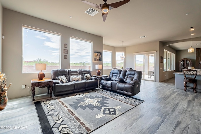 living room with ceiling fan and light hardwood / wood-style flooring