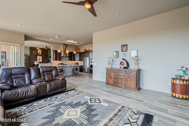 living room with ceiling fan and light wood-type flooring