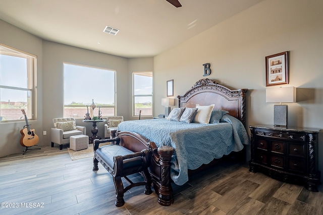 bedroom with dark hardwood / wood-style flooring and ceiling fan