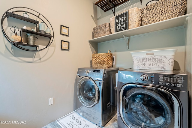 clothes washing area with washer and dryer and hardwood / wood-style floors