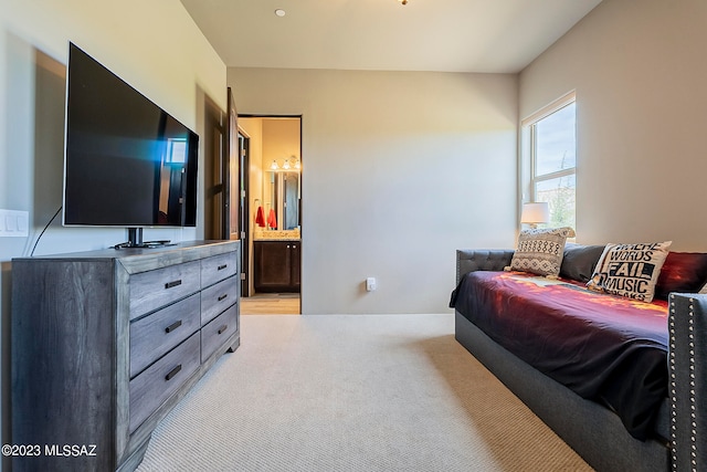 bedroom featuring light carpet and ensuite bath