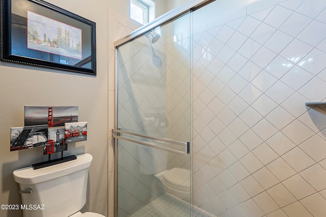 bathroom featuring an enclosed shower and toilet