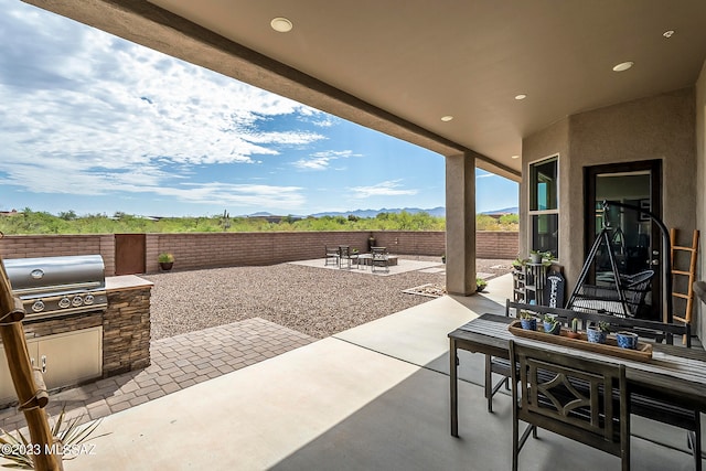 view of terrace with area for grilling and a grill