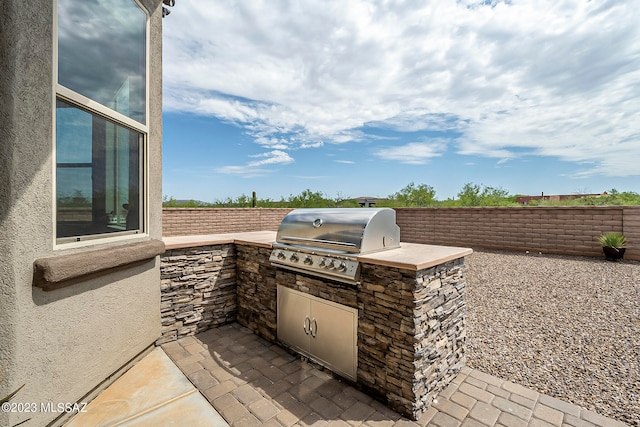 view of patio with an outdoor kitchen and area for grilling