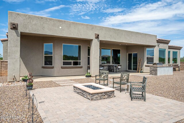 back of house featuring a fire pit and a patio