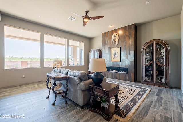 living room with ceiling fan and dark hardwood / wood-style flooring