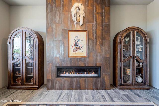 foyer entrance featuring a tile fireplace, tile walls, and light wood-type flooring