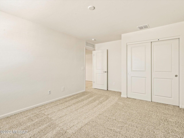 unfurnished bedroom featuring carpet flooring and a closet