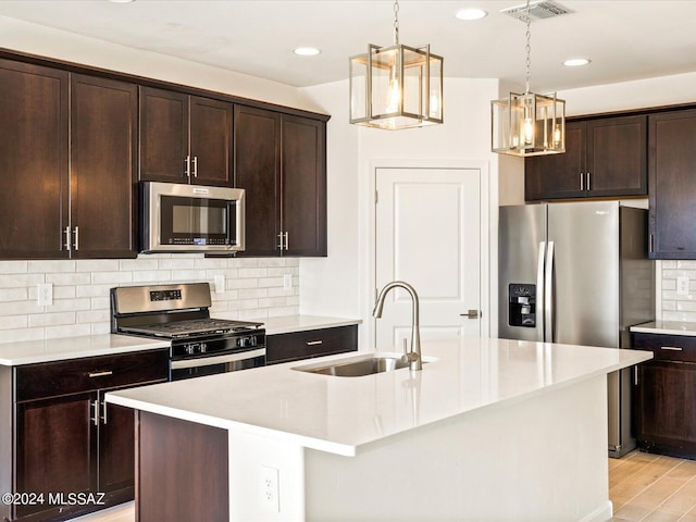 kitchen with appliances with stainless steel finishes and a center island with sink