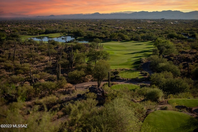 aerial view at dusk featuring a water and mountain view