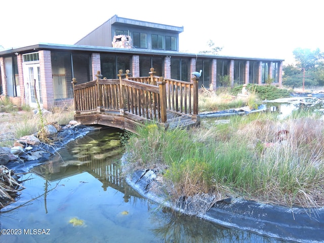 back of house featuring a garden pond