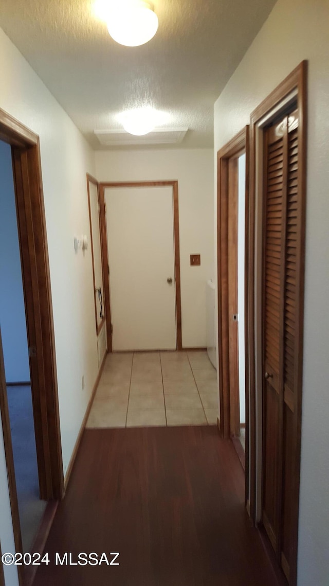 corridor featuring light hardwood / wood-style flooring and a textured ceiling