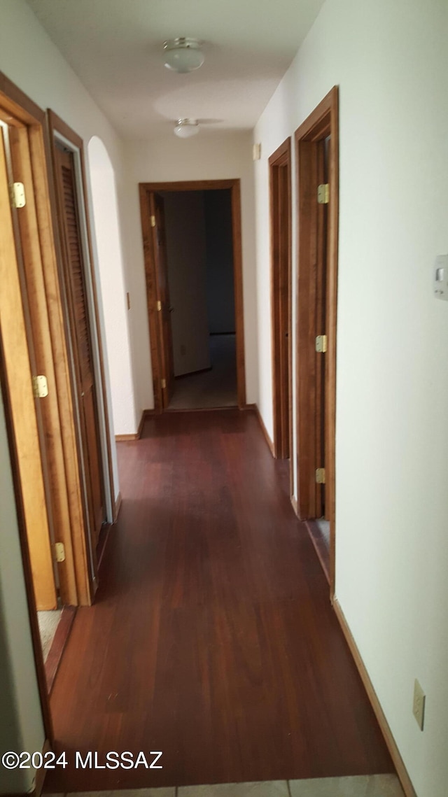 corridor with hardwood / wood-style flooring