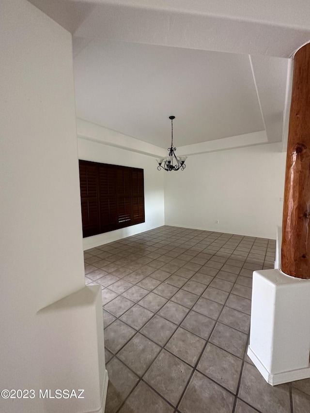 unfurnished living room featuring tile floors, a notable chandelier, and lofted ceiling