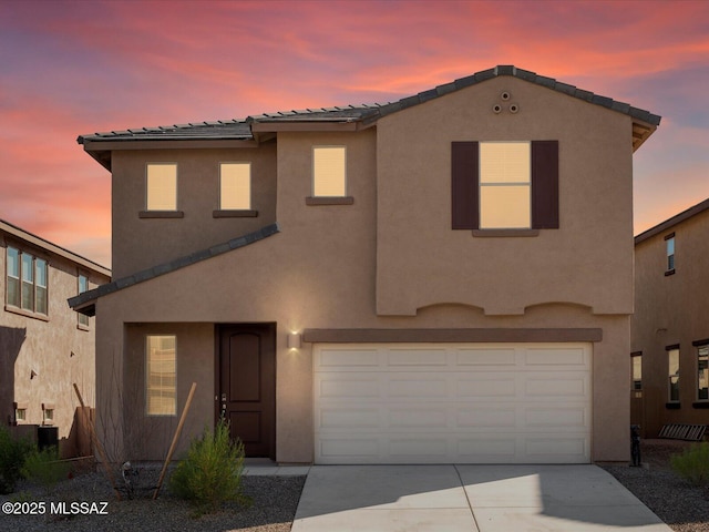 view of front of home with central AC unit, a garage, driveway, a tiled roof, and stucco siding