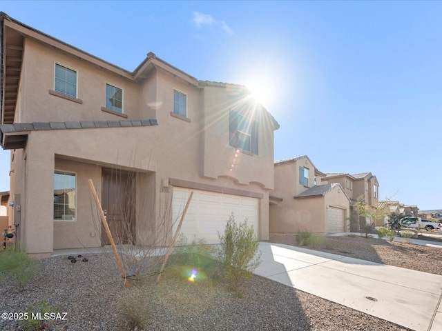 view of front of house featuring concrete driveway, an attached garage, and stucco siding