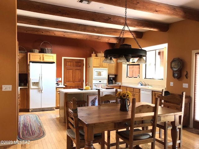 dining room featuring light hardwood / wood-style floors and beamed ceiling