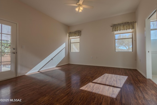 unfurnished room featuring dark hardwood / wood-style floors, a wealth of natural light, and ceiling fan