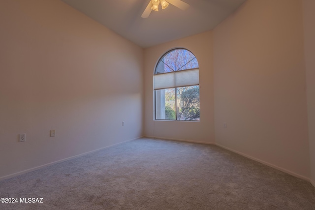 carpeted spare room with vaulted ceiling and ceiling fan