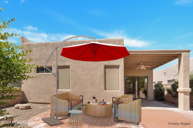 back of property featuring ceiling fan and a patio area