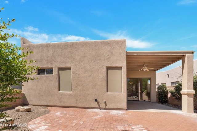 rear view of house with ceiling fan and a patio area