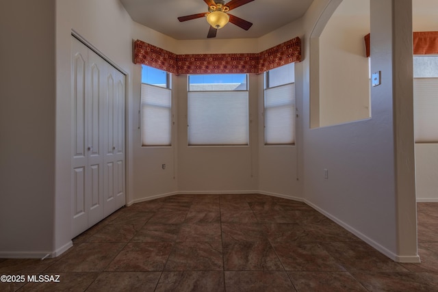 unfurnished room featuring a wealth of natural light and ceiling fan