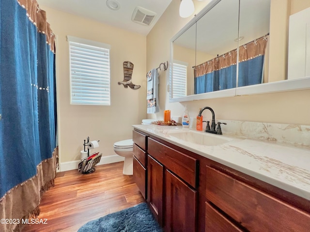 bathroom with hardwood / wood-style floors, vanity, and toilet