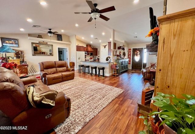 living room featuring wood-type flooring, lofted ceiling, and ceiling fan