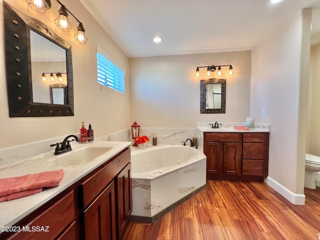 bathroom featuring a tub to relax in, hardwood / wood-style flooring, vanity, and toilet