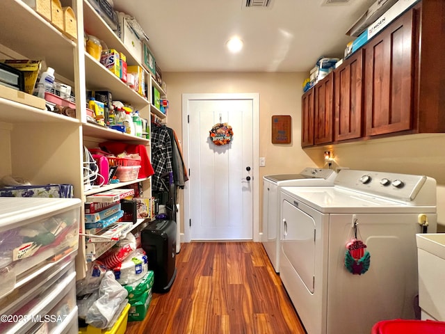 laundry area with separate washer and dryer, dark wood-type flooring, and cabinets