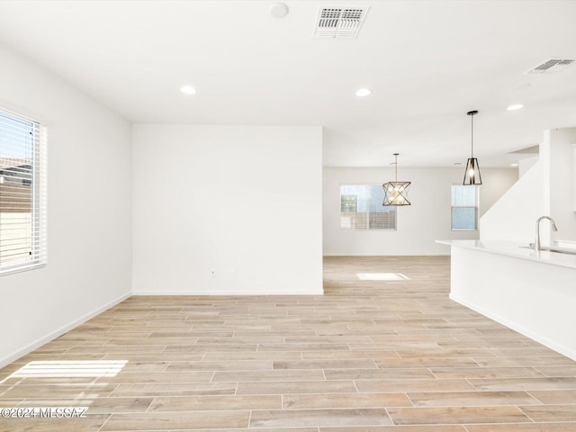 unfurnished room featuring light wood-type flooring and sink