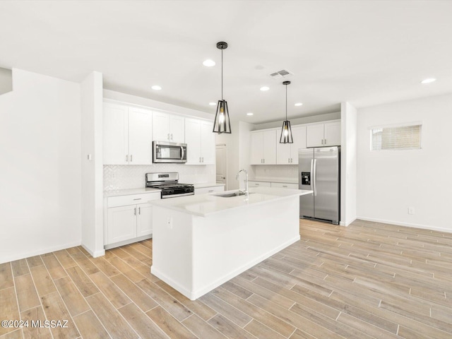 kitchen featuring visible vents, appliances with stainless steel finishes, wood finish floors, and a sink