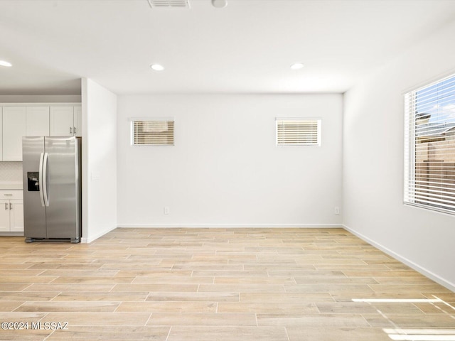 interior space featuring white cabinetry and stainless steel fridge with ice dispenser