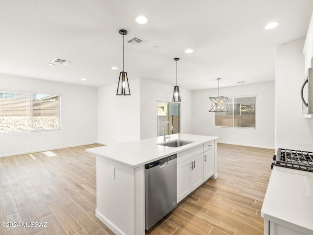 kitchen featuring visible vents, a sink, appliances with stainless steel finishes, light countertops, and wood tiled floor