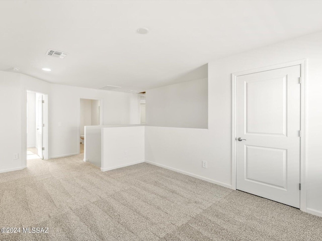 carpeted empty room featuring recessed lighting, visible vents, and baseboards