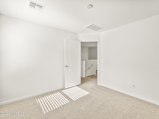 spare room featuring visible vents, baseboards, and carpet