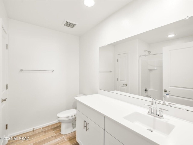 full bathroom with vanity, baseboards, visible vents, wood finish floors, and toilet