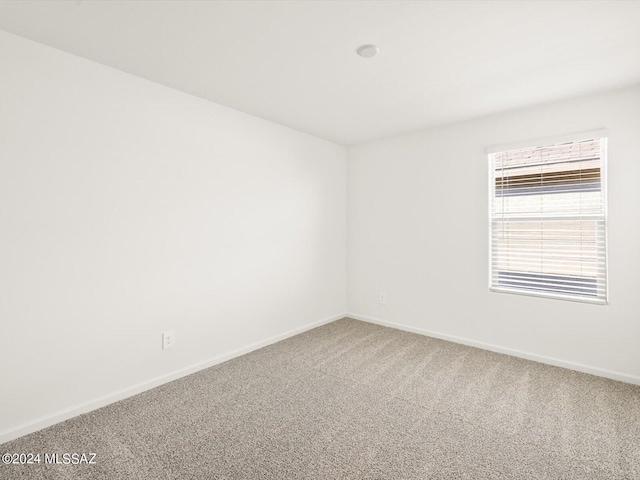 carpeted empty room with baseboards