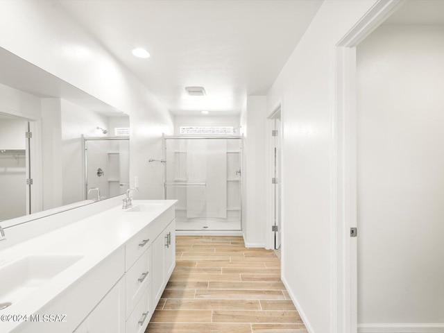 bathroom with a sink, a stall shower, and wood finish floors