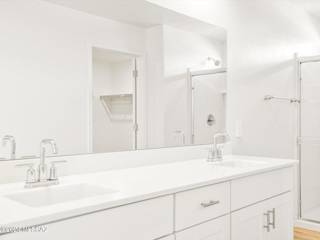 full bath with double vanity, a stall shower, and a sink