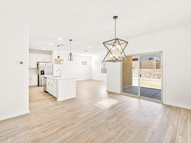 kitchen with light wood finished floors, open floor plan, light countertops, and a sink